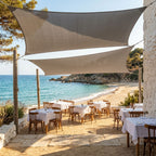 voile d'ombrage grise ombrela au dessus d'un restaurant vue sur la plage et la mer