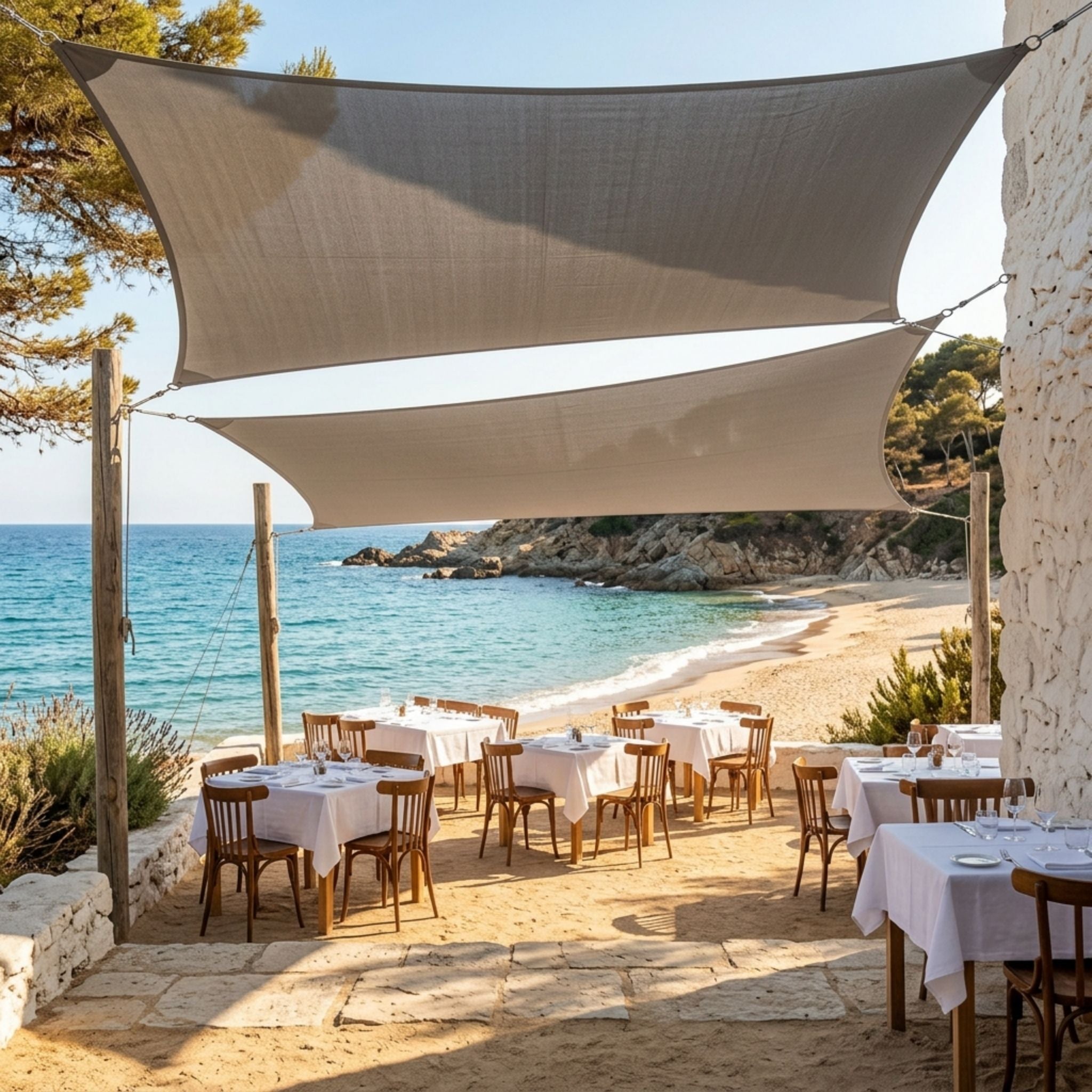 voile d'ombrage grise ombrela au dessus d'un restaurant vue sur la plage et la mer