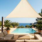 voile d'ombrage beige triangulaire de chez ombrela au dessus d'une terrase avec piscine et vue sur l'océan