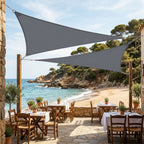 voile d'ombrage triangulaire gris foncé ombrela, au dessus d'une restaurant de plage