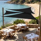 trois voiles d'ombrage triangulaires noir ombrela au dessus d'un restaurant à la plage