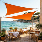 voile d'ombrage triangulaire orange de ombrela au dessus d'une restaurant en bord de plage